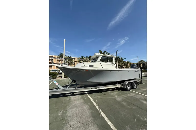  Yacht Photos Pics 2023 Parker 2320 Sport Cabin boat on trailer under clear blue sky.