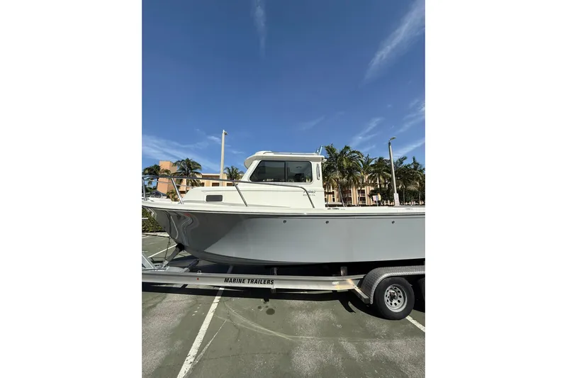  Yacht Photos Pics 2023 Parker 2320 Sport Cabin boat on trailer under clear blue sky.