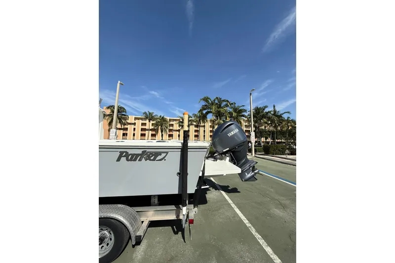  Yacht Photos Pics 2023 Parker 2320 Sport Cabin boat on trailer with Yamaha motor, palm trees in background.