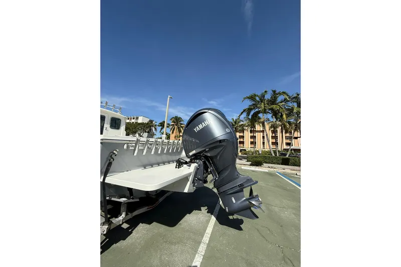  Yacht Photos Pics 2023 Parker 2320 Sport Cabin with Yamaha outboard motor in a sunny parking lot.