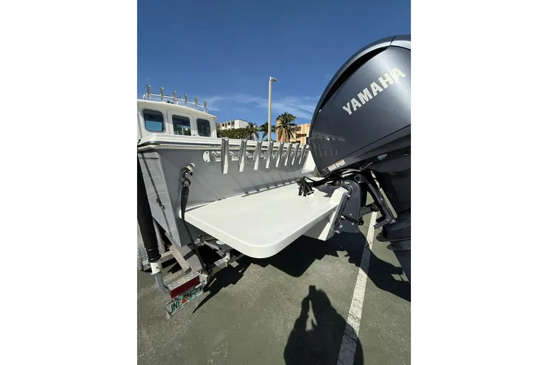  Yacht Photos Pics 2023 Parker 2320 Sport Cabin boat with Yamaha engine, docked under clear blue sky.