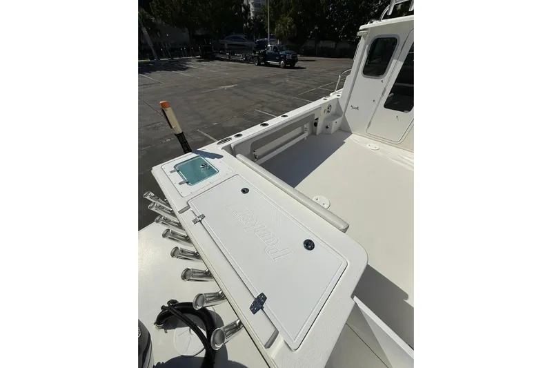  Yacht Photos Pics 2023 Parker 2320 Sport Cabin boat deck with rod holders and storage compartment.