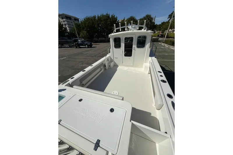 Yacht Photos Pics 2023 Parker 2320 Sport Cabin boat with spacious deck and cabin, parked outdoors.