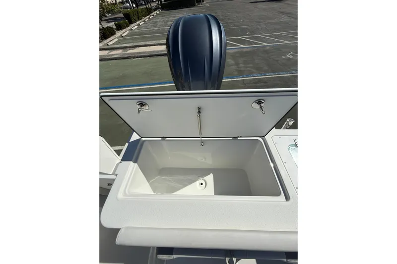  Yacht Photos Pics Open storage compartment on 2023 Parker 2320 Sport Cabin boat, with visible outboard motor.