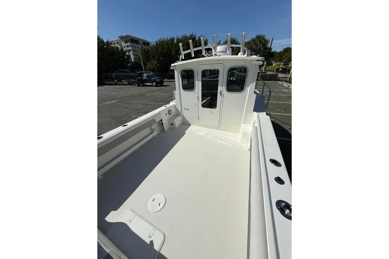  Yacht Photos Pics 2023 Parker 2320 Sport Cabin boat with spacious deck and cabin, parked outdoors.