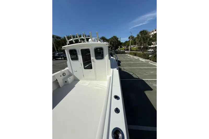  Yacht Photos Pics 2023 Parker 2320 Sport Cabin boat in parking lot, showcasing cabin and deck features.