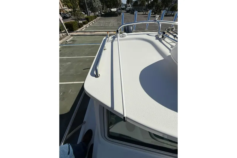  Yacht Photos Pics 2023 Parker 2320 Sport Cabin boat deck with railing, parked in a lot.