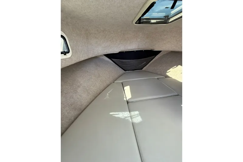  Yacht Photos Pics 2023 Parker 2320 Sport Cabin interior with cushioned seating and overhead window.