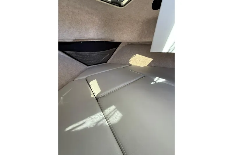  Yacht Photos Pics 2023 Parker 2320 Sport Cabin interior with cushioned seating and storage net.