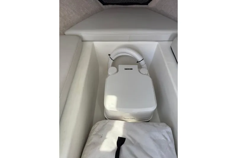  Yacht Photos Pics 2023 Parker 2320 Sport Cabin interior with portable toilet and white seating.