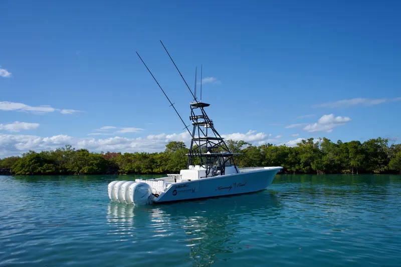  Yacht Photos Pics 2019 SeaHunter 45 Tournament boat on calm water, clear blue sky, lush green shoreline.