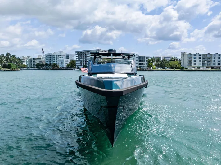 Green Eyes Yacht Photos Pics 2023 Wally Wallytender 43X yacht cruising on a sunny day with buildings in the background.
