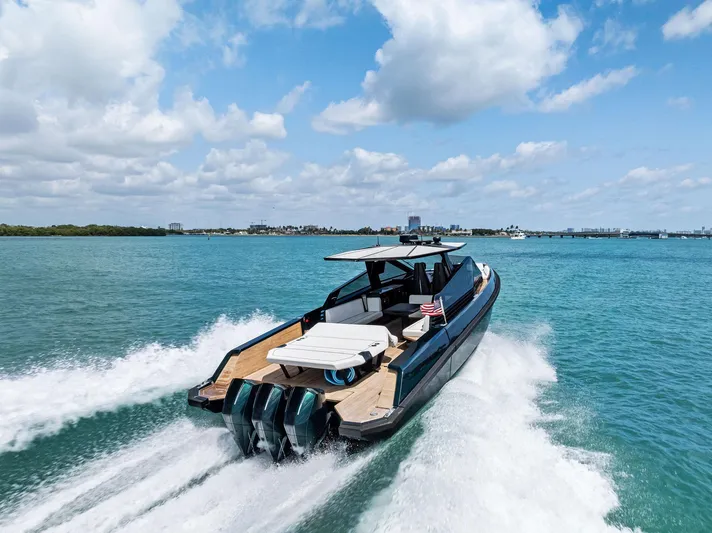 Green Eyes Yacht Photos Pics 2023 Wally Wallytender 43X cruising on clear blue water under a partly cloudy sky.