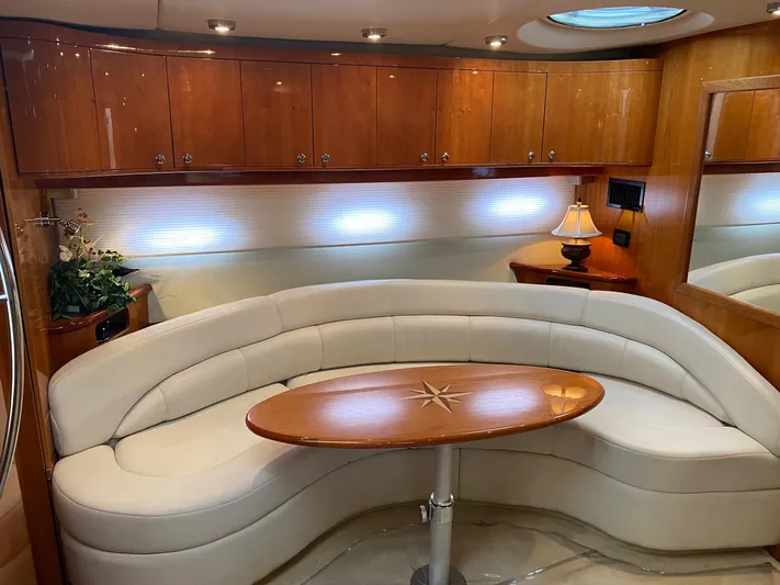Making Memories Yacht Photos Pics Luxurious interior of 2005 Regal Commodore 4260 yacht with curved seating and wooden table.