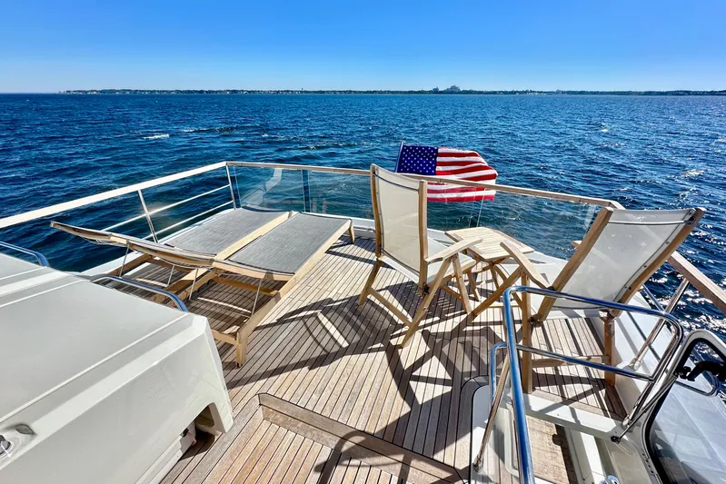  Yacht Photos Pics Luxury Absolute 72 FLY yacht deck with chairs, American flag, and ocean view, 2016 model.