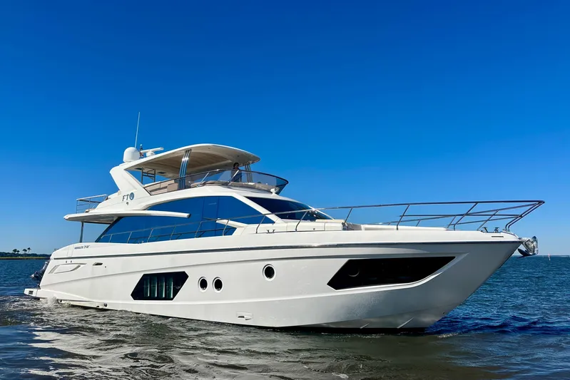  Yacht Photos Pics Luxury 2016 Absolute 72 FLY yacht cruising on open water under clear blue sky.