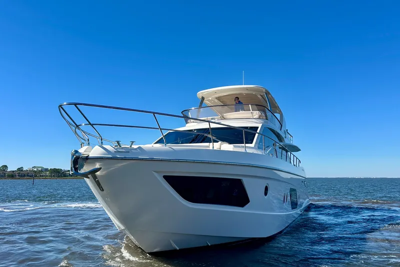  Yacht Photos Pics Luxurious 2016 Absolute 72 FLY yacht cruising on open water under clear blue skies.