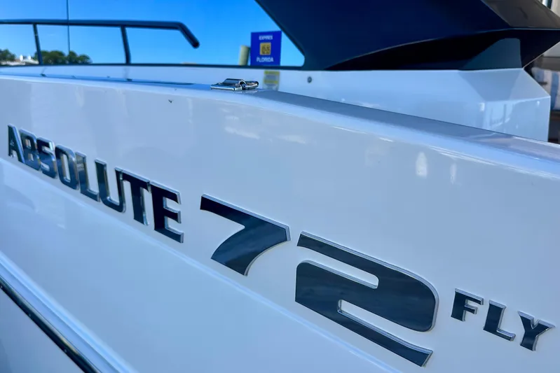  Yacht Photos Pics Close-up of Absolute 72 FLY yacht nameplate, 2016 model, in a marina setting.