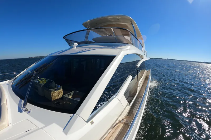  Yacht Photos Pics Luxurious 2016 Absolute 72 FLY yacht cruising on open water under clear blue skies.