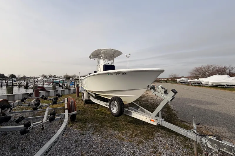  Yacht Photos Pics Contender boat on trailer at marina, overcast sky, docked boats in background.