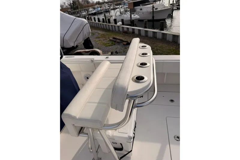  Yacht Photos Pics Contender boat seat with rod holders, docked near other boats in a marina.