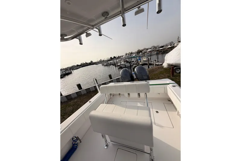  Yacht Photos Pics Contender boat with dual engines docked at a marina, overlooking calm waters.