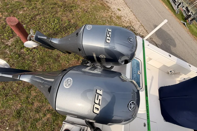 Yacht Photos Pics Twin Yamaha 150 outboard motors on a Contender boat, parked on grass.