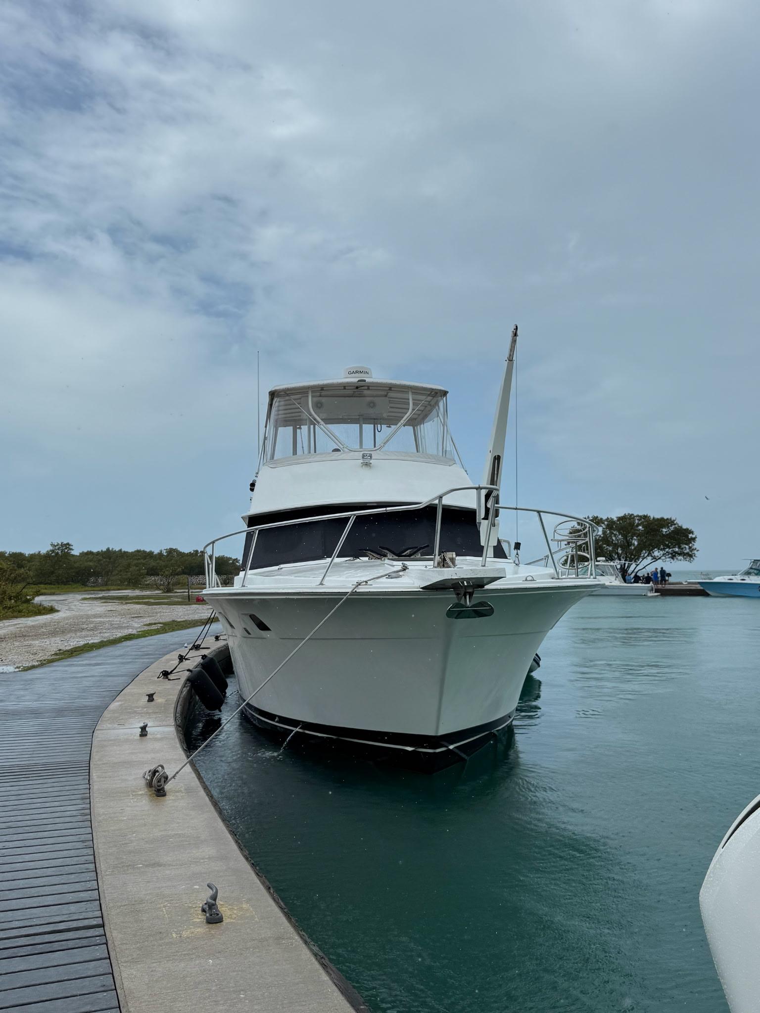 1985 Bertram 46 Convertible yacht docked in a serene marina setting.