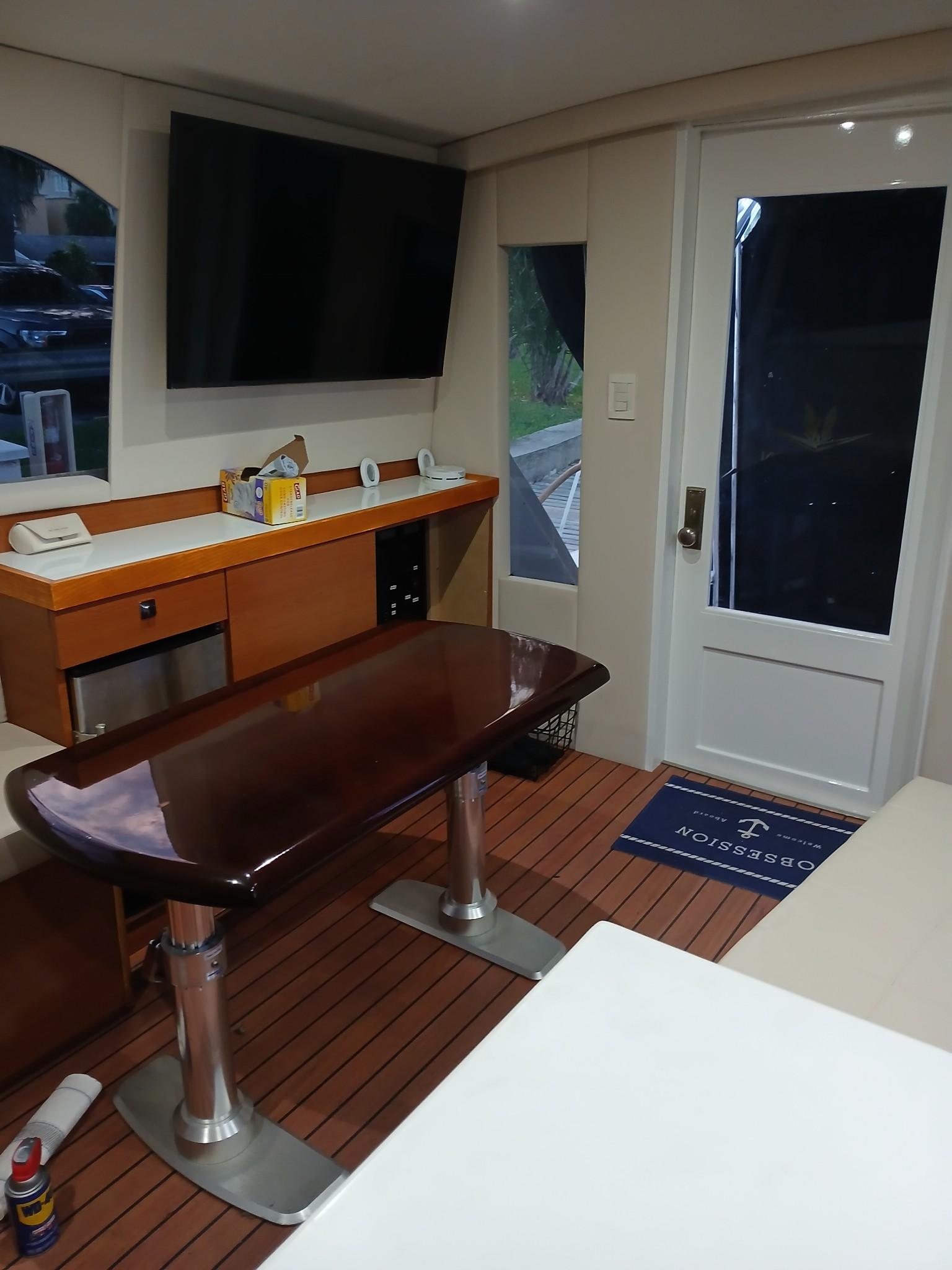 Interior of a 1985 Bertram 46 Convertible yacht with modern amenities and wooden flooring.