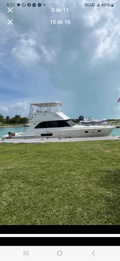  Yacht Photos Pics 1985 Bertram 46 Convertible yacht docked by the water under a cloudy sky.