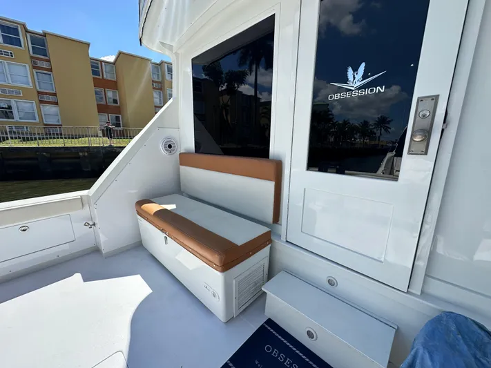  Yacht Photos Pics 1985 Bertram 46 Convertible yacht deck with seating and "Obsession" logo on door.
