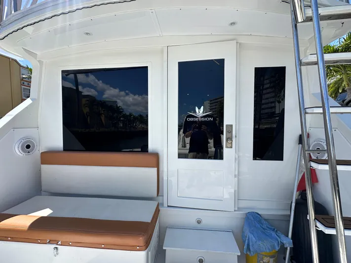 Yacht Photos Pics 1985 Bertram 46 Convertible yacht with seating and glass door, docked under clear skies.