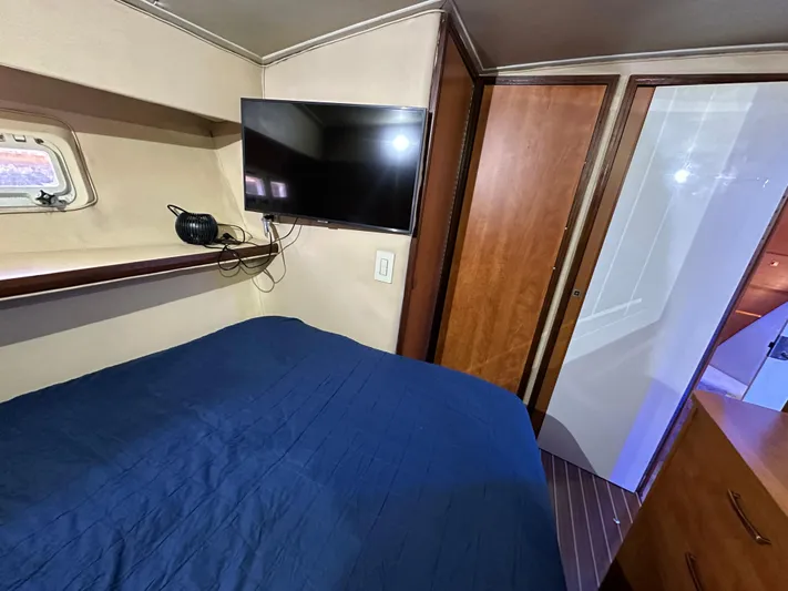  Yacht Photos Pics Cozy bedroom in 1985 Bertram 46 Convertible yacht with TV and blue bedding.