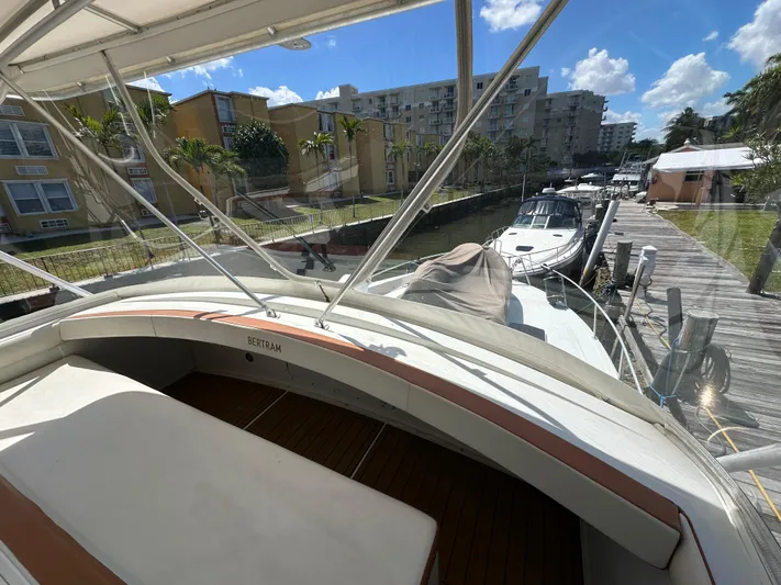  Yacht Photos Pics 1985 Bertram 46 Convertible yacht docked near waterfront homes under a clear blue sky.