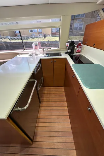  Yacht Photos Pics 1985 Bertram 46 Convertible yacht kitchen with modern appliances and wooden flooring.