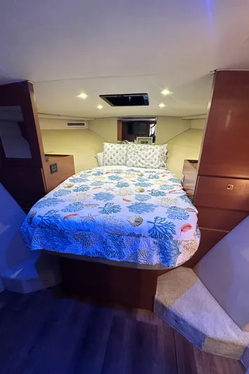  Yacht Photos Pics Cozy bedroom in 1985 Bertram 46 Convertible yacht with floral bedding and ambient lighting.