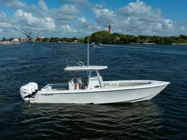 Baker Acted Yacht Photos Pics 2020 Contender 35ST boat cruising on a scenic waterway with a lighthouse in the background.