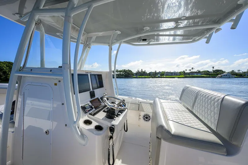 Baker Acted Yacht Photos Pics 2020 Contender 35ST boat interior with helm station and seating, overlooking calm waters.