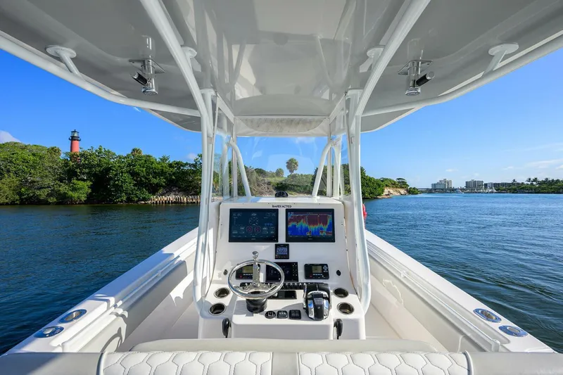 Baker Acted Yacht Photos Pics 2020 Contender 35ST boat dashboard with navigation screens on a scenic waterway.