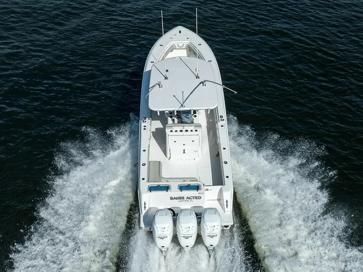 Baker Acted Yacht Photos Pics 2020 Contender 35ST boat cruising on water, rear view.