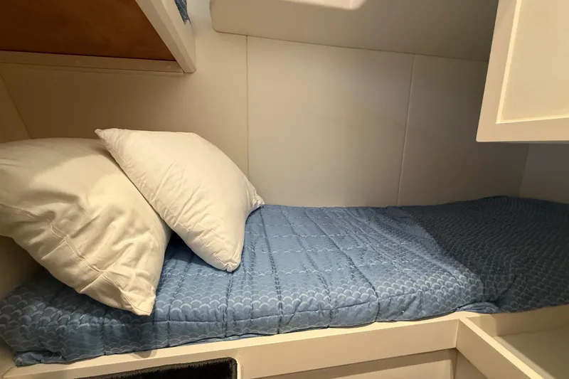  Yacht Photos Pics Cozy cabin bed in 2021 Itama 45 S yacht with blue bedding and white pillows.