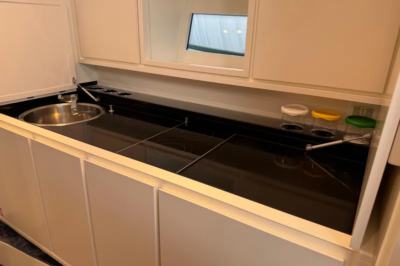  Yacht Photos Pics Modern kitchen area in a 2021 Itama 45 S yacht, featuring sleek countertops and a round sink.