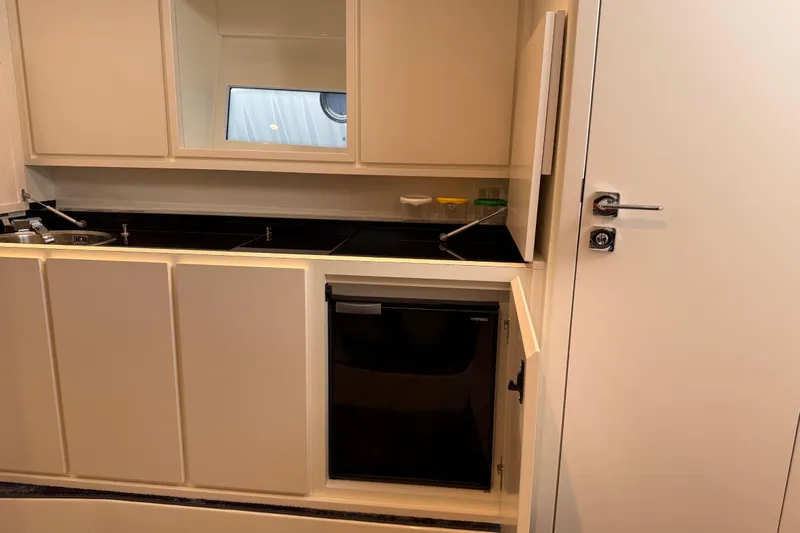 Yacht Photos Pics Modern kitchen interior on 2021 Itama 45 S yacht with compact fridge and sleek cabinetry.