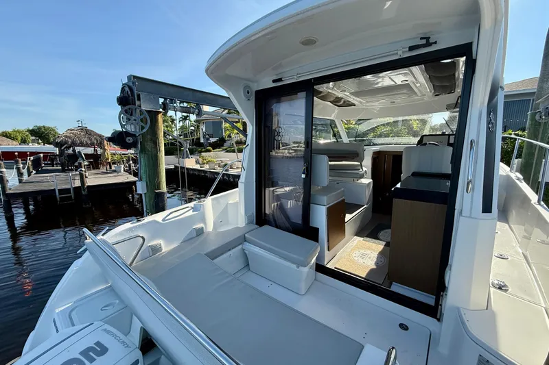  Yacht Photos Pics 2022 Beneteau Antares 9 boat interior with open sliding door, dockside view.