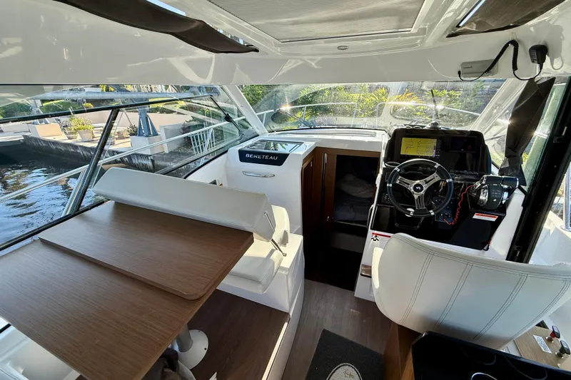  Yacht Photos Pics Interior of 2022 Beneteau Antares 9 boat with helm, seating, and table.