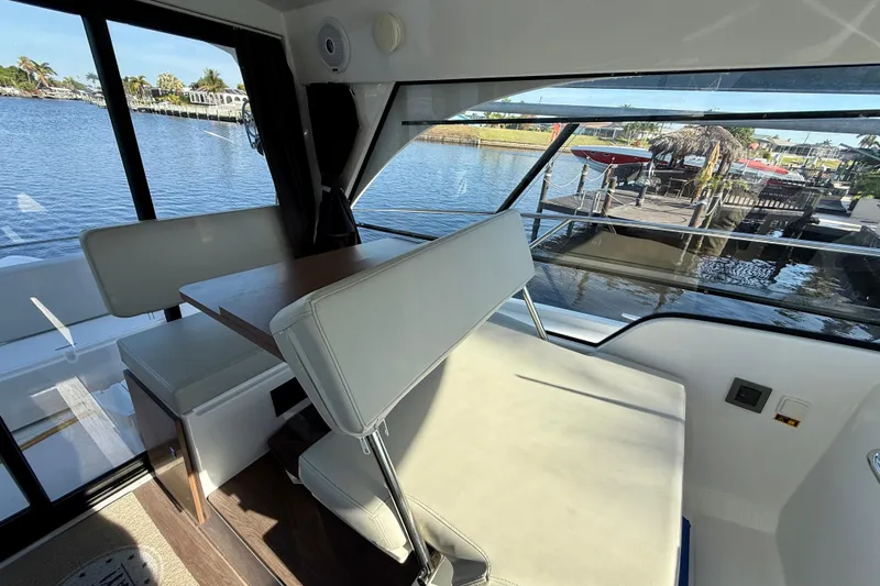 Yacht Photos Pics Interior view of 2022 Beneteau Antares 9 with seating and waterfront scenery.