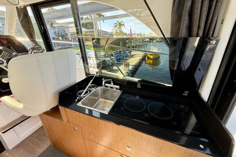  Yacht Photos Pics Interior of 2022 Beneteau Antares 9, featuring a compact kitchen with sink and stove.