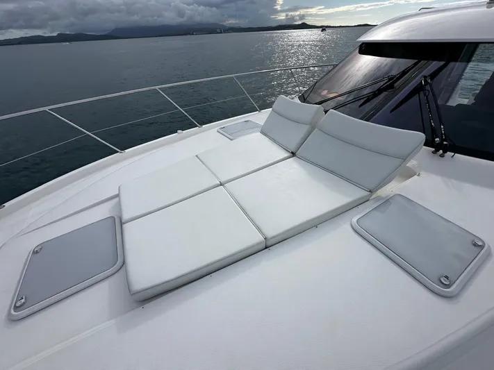  Yacht Photos Pics 2016 Riviera 5000 Sport Yacht with sun loungers on deck, ocean view in background.