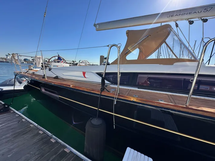 Dharma Yacht Photos Pics 2013 Jeanneau 57 yacht docked at marina under clear blue sky.