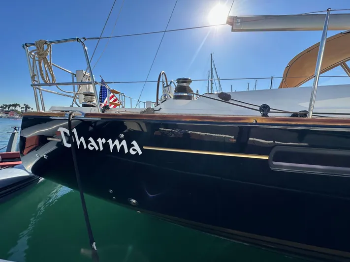 Dharma Yacht Photos Pics Jeanneau 57 sailboat named Charma docked under sunny sky, 2013 model.